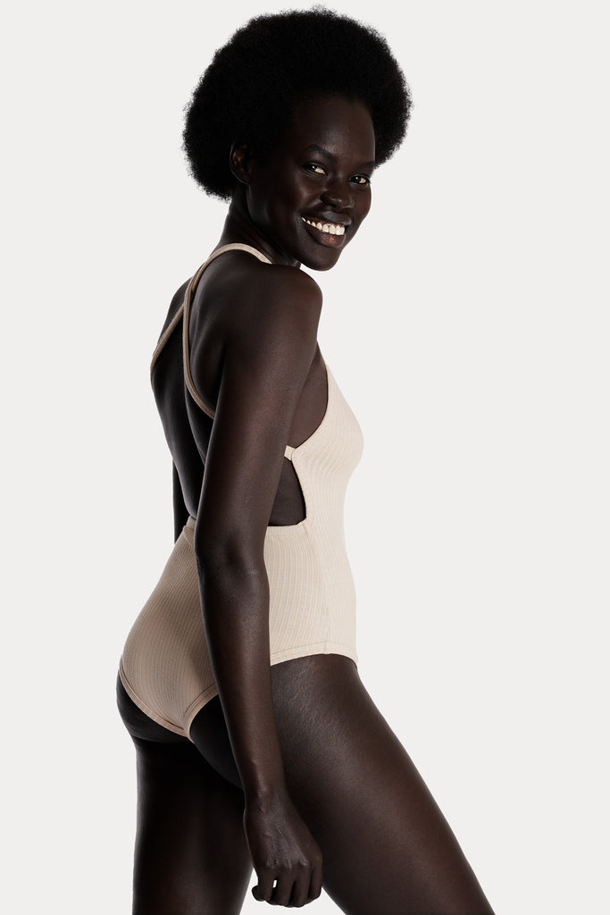 Model wearing a sand ribbed bodysuit right-side closeup.