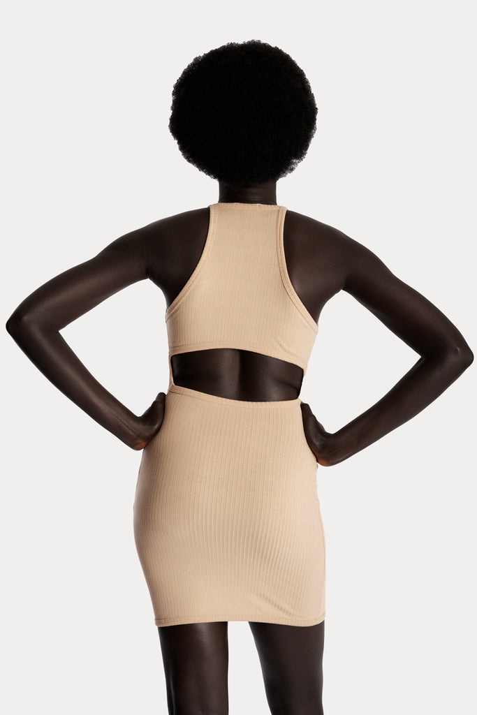 Model wearing a tan ribbed mini dress, back-side close-up view.