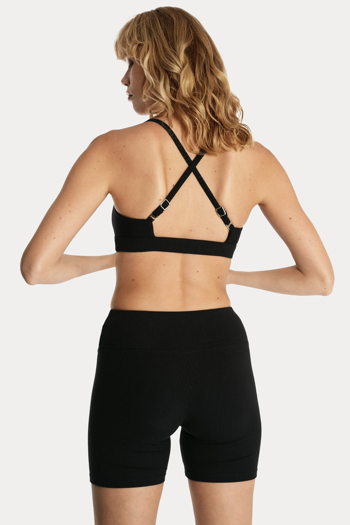 Lenzing ecovero eco rib jersey knit bralette with crossed straps in black with knit biker shorts in black back side closeup view.